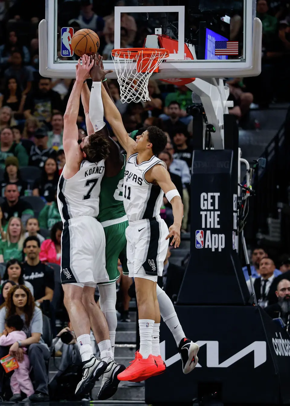 San Antonio Spurs center Luke Kornet (7) and forward Carter Bryant (11) fight Boston Celtics center Neemias Queta (88) for the rebound during an NBA game at Frost Bank Center in San Antonio, Tuesday, March 10, 2026. The Spurs defeated the Celtics 125-116.