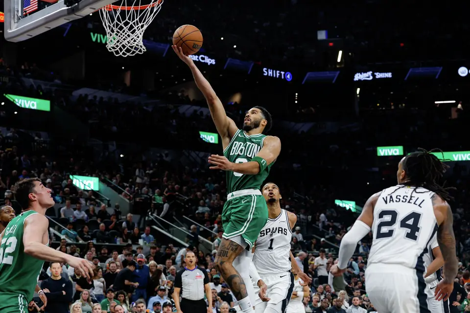 Boston Celtics forward Jayson Tatum (0) lays the ball into the net over San Antonio Spurs forward Victor Wembanyama (1) and guard Devin Vassell (24) at Frost Bank Center in San Antonio, Tuesday, March 10, 2026. The Spurs defeated the Celtics 125-116.