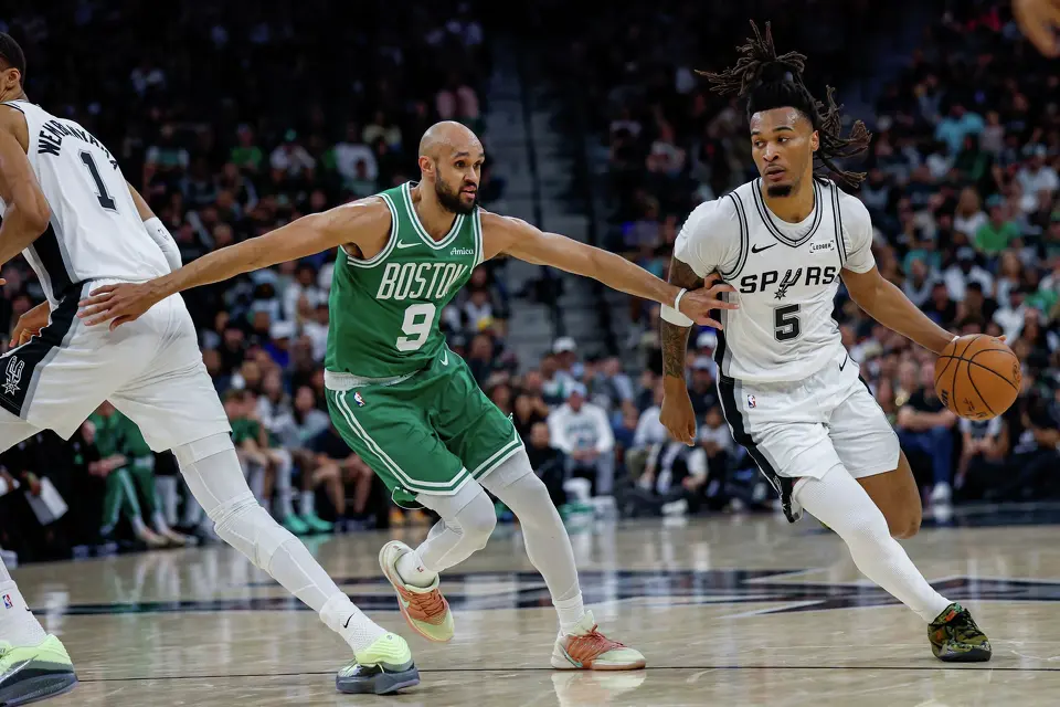 San Antonio Spurs guard Stephon Castle (5) drives around Boston Celtics guard Derrick White (9) during the game at Frost Bank Center in San Antonio, Tuesday, March 10, 2026.