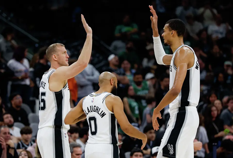 San Antonio Spurs’ Mason Plumlee (22) and Victor Wembanyama (1) high-five over their teammate Jordan McLaughlin (0) during the fourth quarter against the Boston Celtics at Frost Bank Center in San Antonio, Tuesday, March 10, 2026. The Spurs defeated the Celtics 125-116.