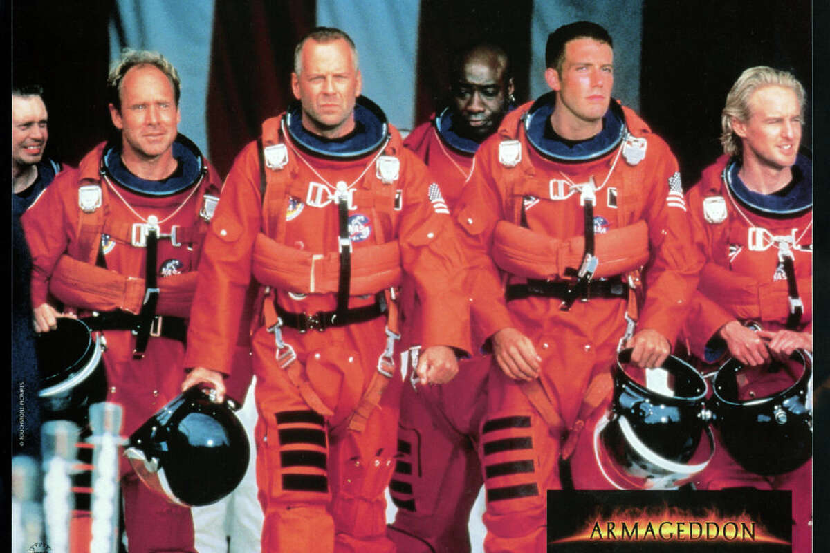 Steve Buscemi, Will Patton, Bruce Willis, Michael Clarke Duncan, Ben Affleck, and Owen Wilson walking in NASA uniforms in a scene from the film 'Armageddon', 1998. (Photo by Touchstone/Getty Images)