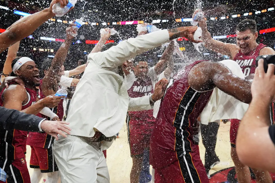Miami Heat center Bam Adebayo, right, his head covered in a towel, is doused with water by teammates after he scored 83 points, the second-highest single game total in NBA history, in an NBA basketball game against the Washington Wizards, Tuesday, March 10, 2026, in Miami. (AP Photo/Rebecca Blackwell)