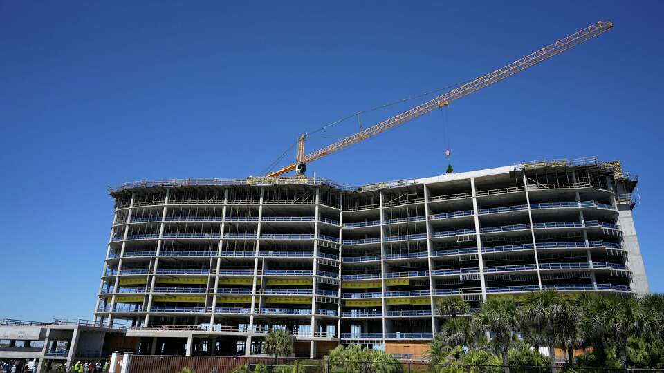 During the topping out ceremony, a crane places a tree on the top level during construction of Tiara on the Beach, a 10-story Miami-inspired luxury condo project, on the West End of Galveston's Seawall Thursday, March 12, 2026.
