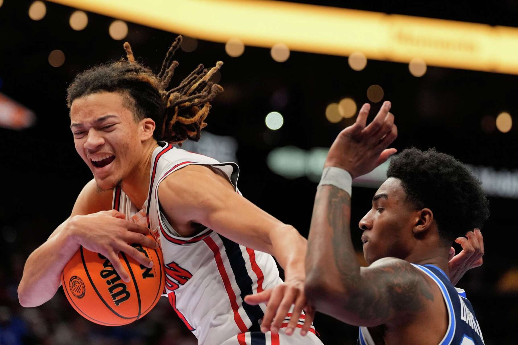 Houston's Kingston Flemings, left, grabs a rebound as BYU's Kennard Davis Jr. watches during the first half of an NCAA college basketball game in the quarterfinal round of the Big 12 Conference tournament Thursday, March 12, 2026, in Kansas City, Mo. (AP Photo/Charlie Riedel)