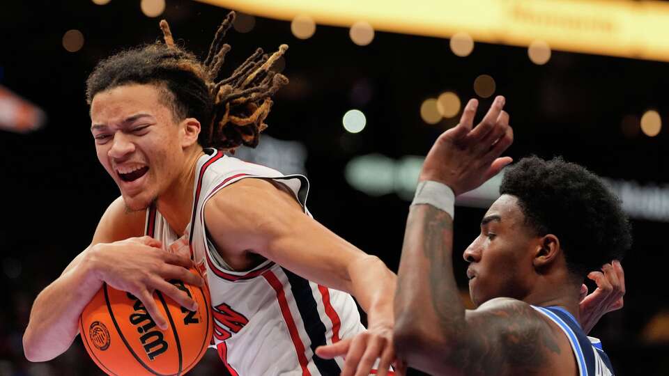 Houston's Kingston Flemings, left, grabs a rebound as BYU's Kennard Davis Jr. watches during the first half of an NCAA college basketball game in the quarterfinal round of the Big 12 Conference tournament Thursday, March 12, 2026, in Kansas City, Mo. (AP Photo/Charlie Riedel)
