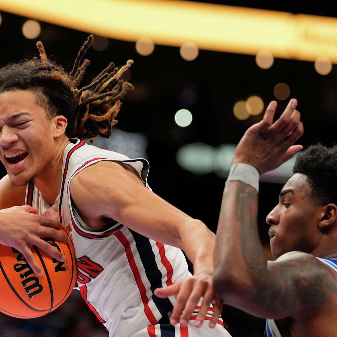 Houston's Kingston Flemings, left, grabs a rebound as BYU's Kennard Davis Jr. watches during the first half of an NCAA college basketball game in the quarterfinal round of the Big 12 Conference tournament Thursday, March 12, 2026, in Kansas City, Mo. (AP Photo/Charlie Riedel)
