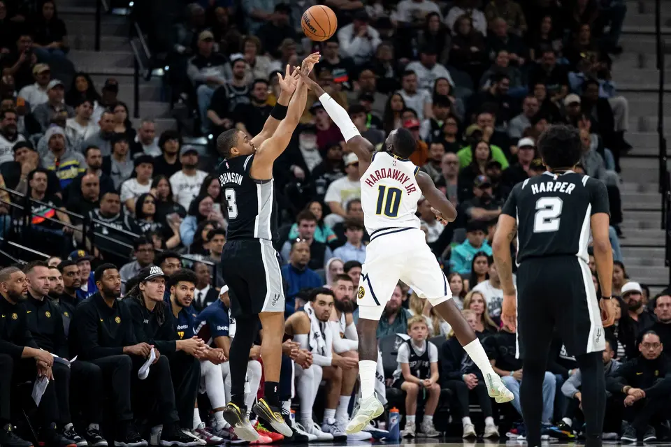 San Antonio Spurs forward Keldon Johnson (3) shoots the ball as Denver Nuggets guard Tim Hardaway Jr. (10) defends at Frost Bank Center in San Antonio on Thursday, March 12, 2026.
