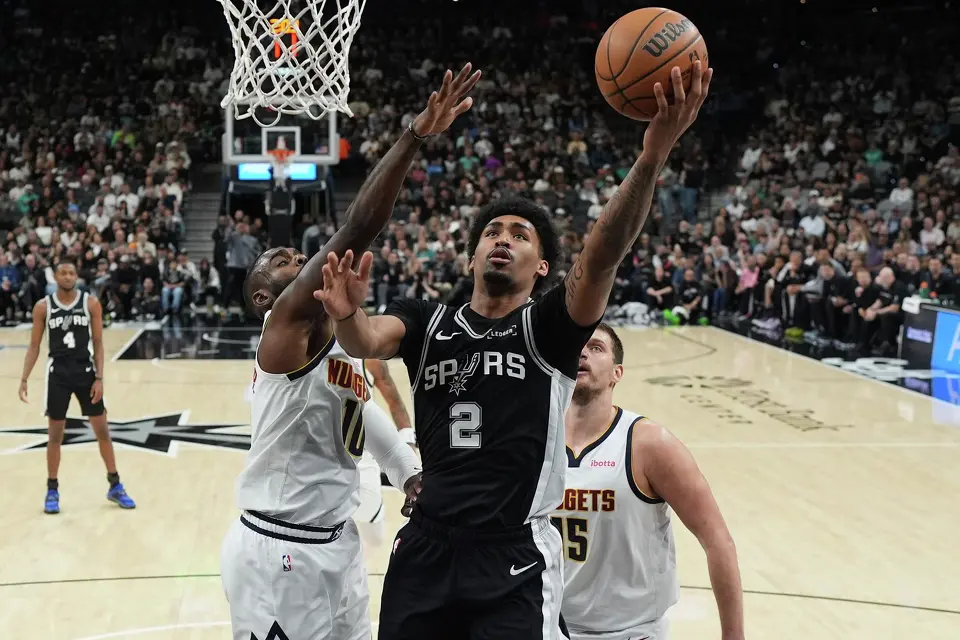 San Antonio Spurs guard Dylan Harper (2) drives to the basket against Denver Nuggets guard Tim Hardaway Jr. (10) during the first half of an NBA basketball game in San Antonio, Thursday, March 12, 2026.