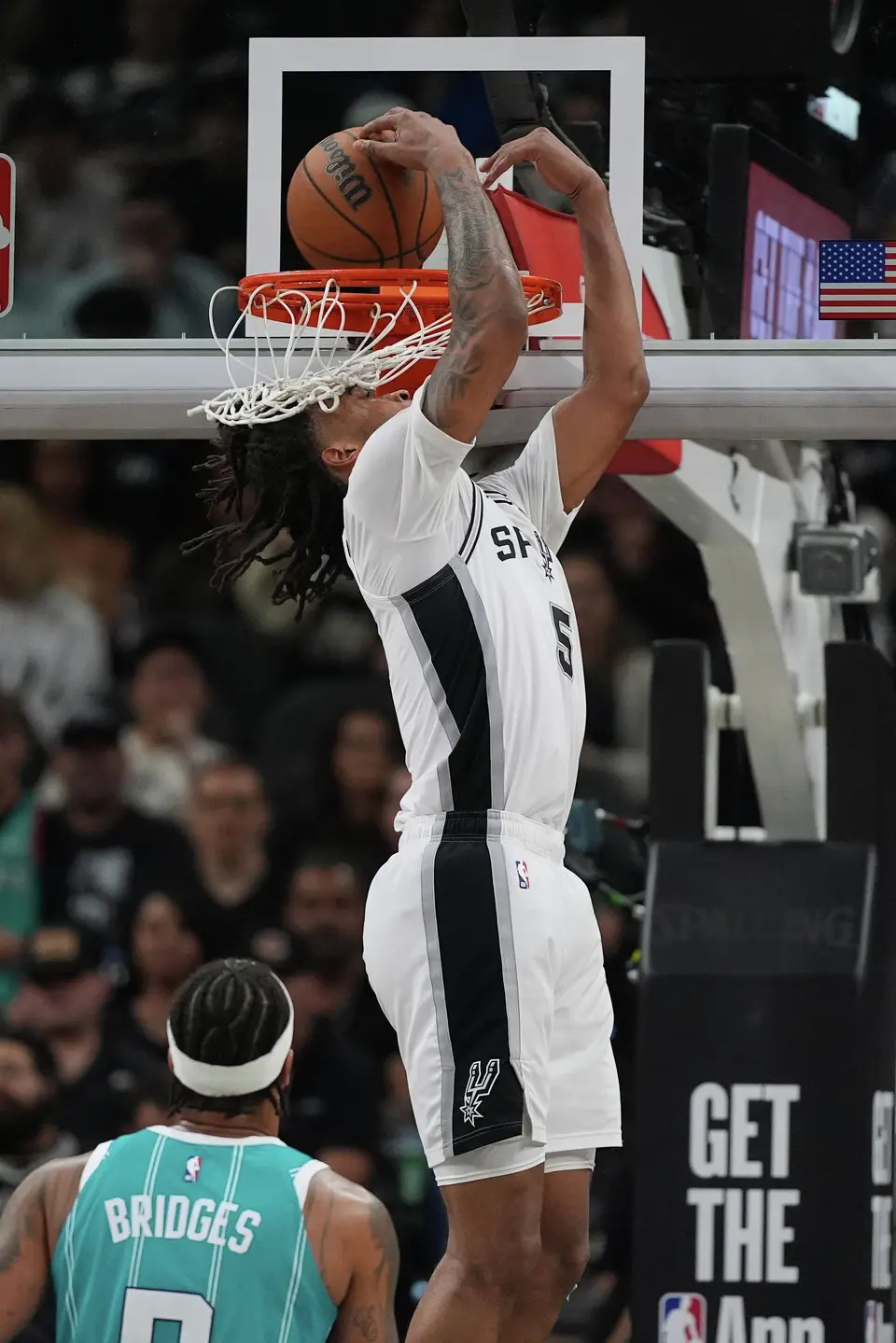San Antonio Spurs guard Stephon Castle (5) scores over Charlotte Hornets forward Miles Bridges (0) during the second half of an NBA basketball game in San Antonio, Saturday, March 14, 2026. (AP Photo/Eric Gay)