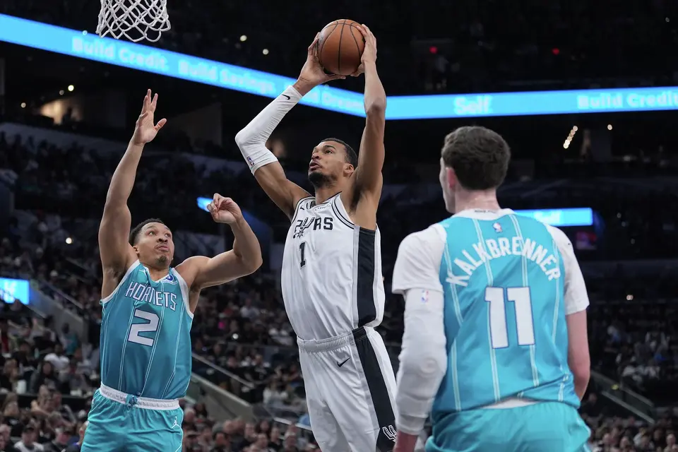 San Antonio Spurs forward Victor Wembanyama (1) drives to the basket against Charlotte Hornets forward Grant Williams (2) during the first half of an NBA basketball game in San Antonio, Saturday, March 14, 2026. (AP Photo/Eric Gay)