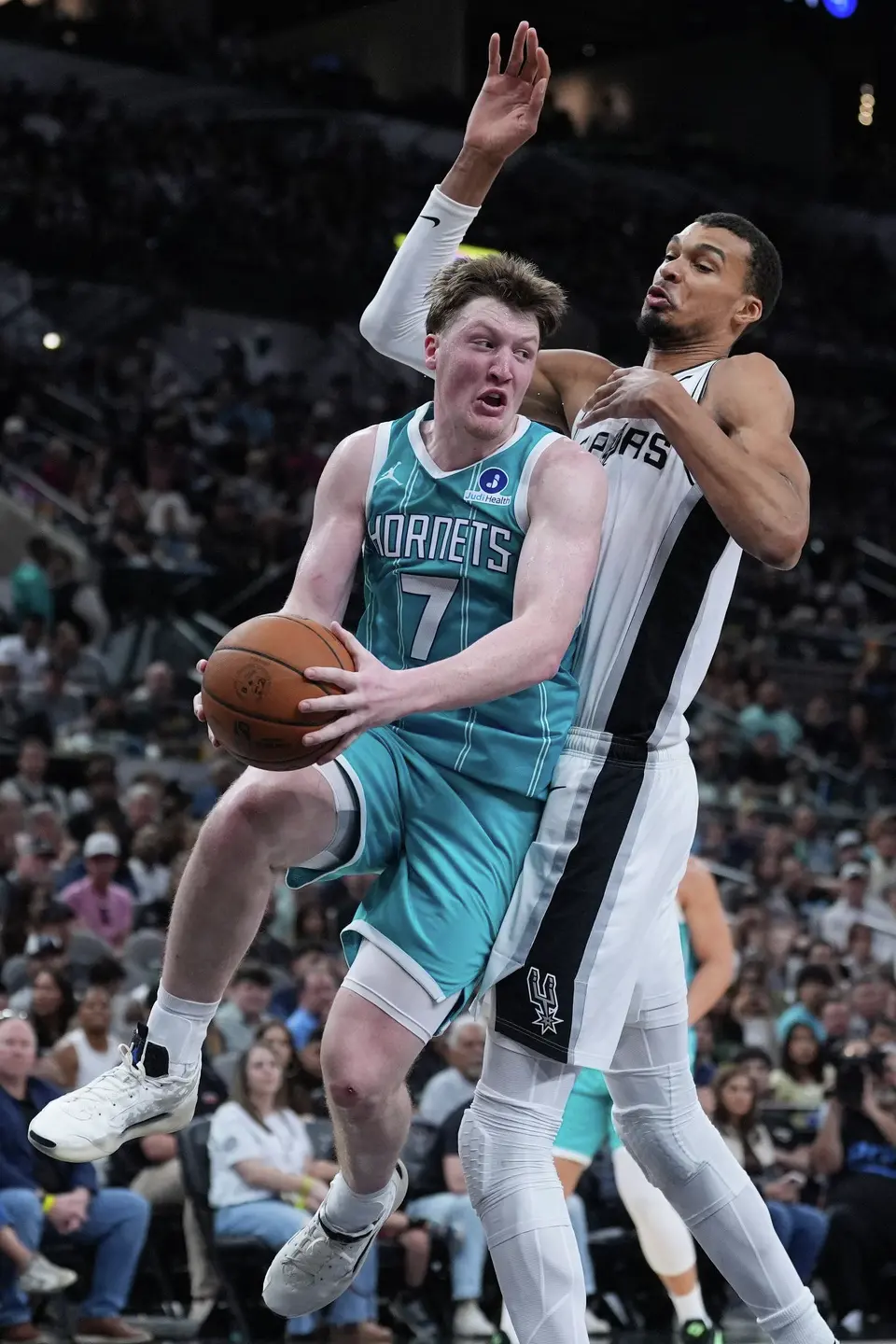 Charlotte Hornets guard Kon Knueppel (7) drives against San Antonio Spurs forward Victor Wembanyama (1) during the second half of an NBA basketball game in San Antonio, Saturday, March 14, 2026. (AP Photo/Eric Gay)