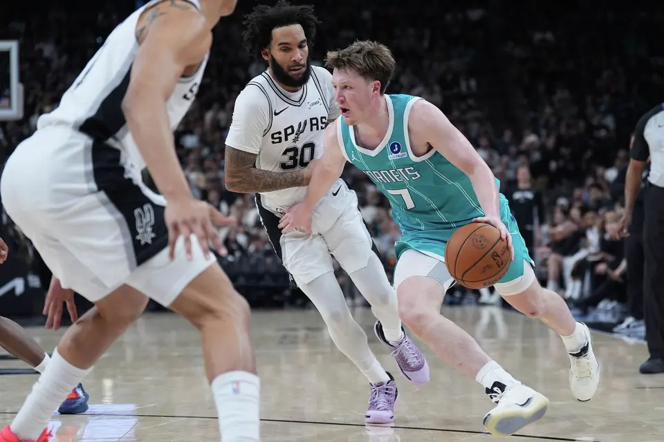 Charlotte Hornets guard Kon Knueppel (7) drives around San Antonio Spurs forward Julian Champagnie (30) during the second half of an NBA basketball game in San Antonio, Saturday, March 14, 2026. (AP Photo/Eric Gay)