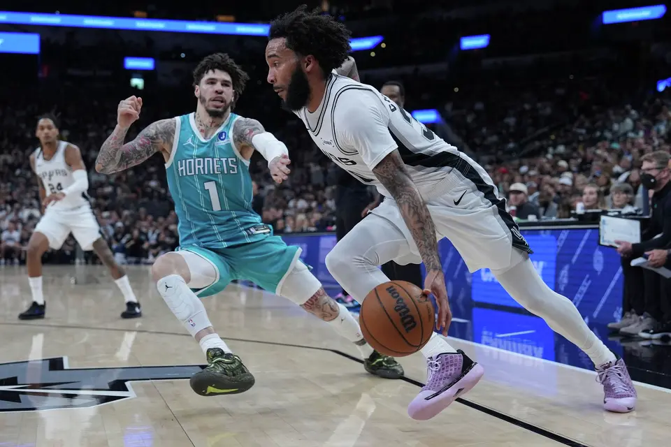 San Antonio Spurs forward Julian Champagnie (30) drives against Charlotte Hornets guard LaMelo Ball (1) during the first half of an NBA basketball game in San Antonio, Saturday, March 14, 2026. (AP Photo/Eric Gay)