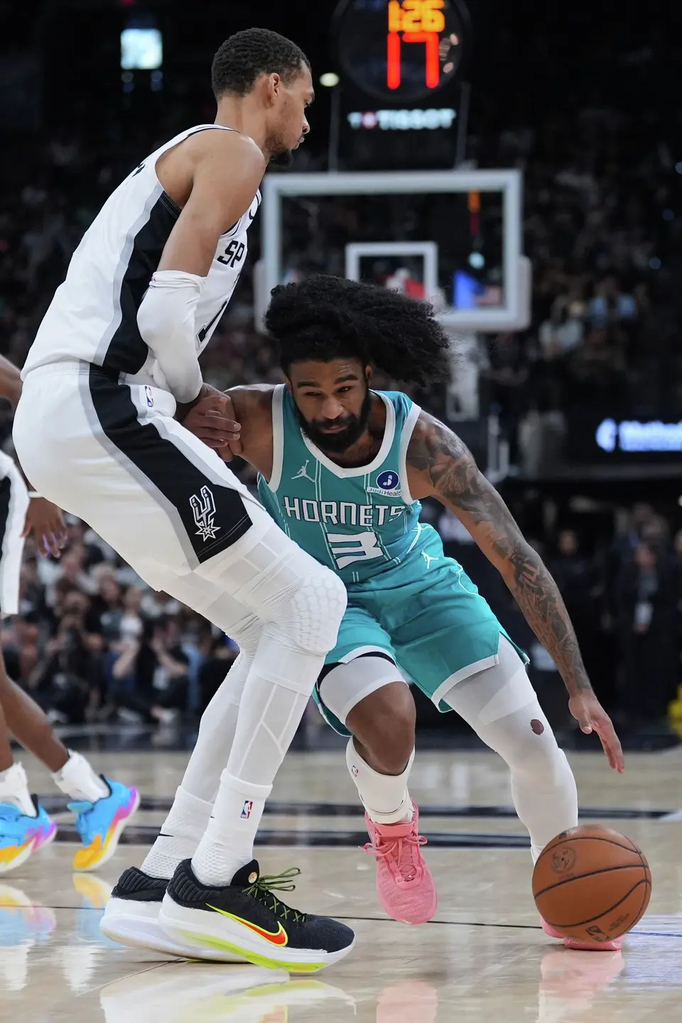 Charlotte Hornets guard Coby White (3) drives against San Antonio Spurs forward Victor Wembanyama (1) during the second half of an NBA basketball game in San Antonio, Saturday, March 14, 2026. (AP Photo/Eric Gay)