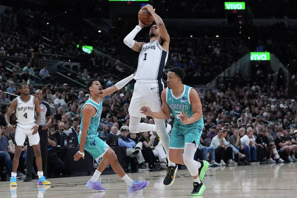San Antonio Spurs forward Victor Wembanyama (1) shoots over Charlotte Hornets forward Grant Williams (2) and guard Josh Green (10) during the first half of an NBA basketball game in San Antonio, Saturday, March 14, 2026. (AP Photo/Eric Gay)