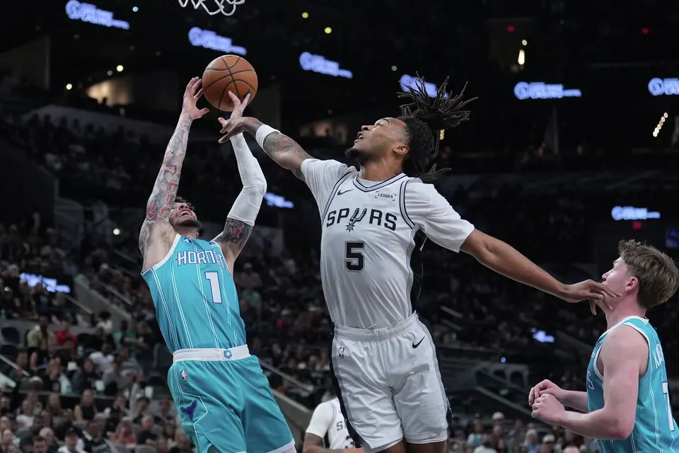 Charlotte Hornets guard LaMelo Ball (1) grabs a rebound over San Antonio Spurs guard Stephon Castle (5) during the first half of an NBA basketball game in San Antonio, Saturday, March 14, 2026. (AP Photo/Eric Gay)