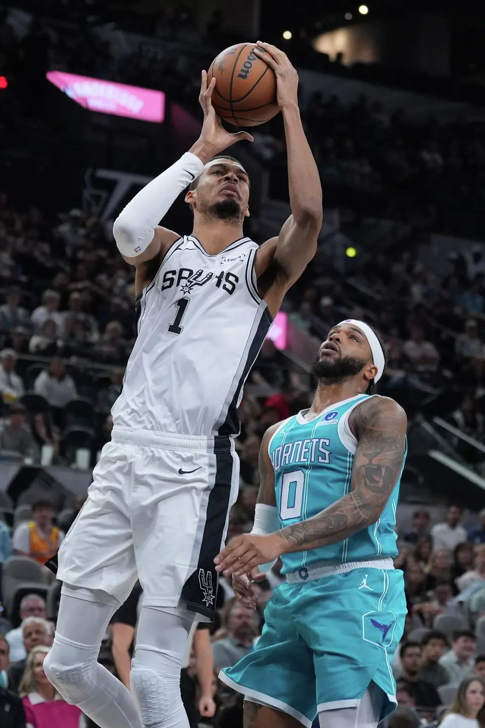 San Antonio Spurs forward Victor Wembanyama (1) drives to the basket against Charlotte Hornets forward Miles Bridges (0) during the first half of an NBA basketball game in San Antonio, Saturday, March 14, 2026. (AP Photo/Eric Gay)