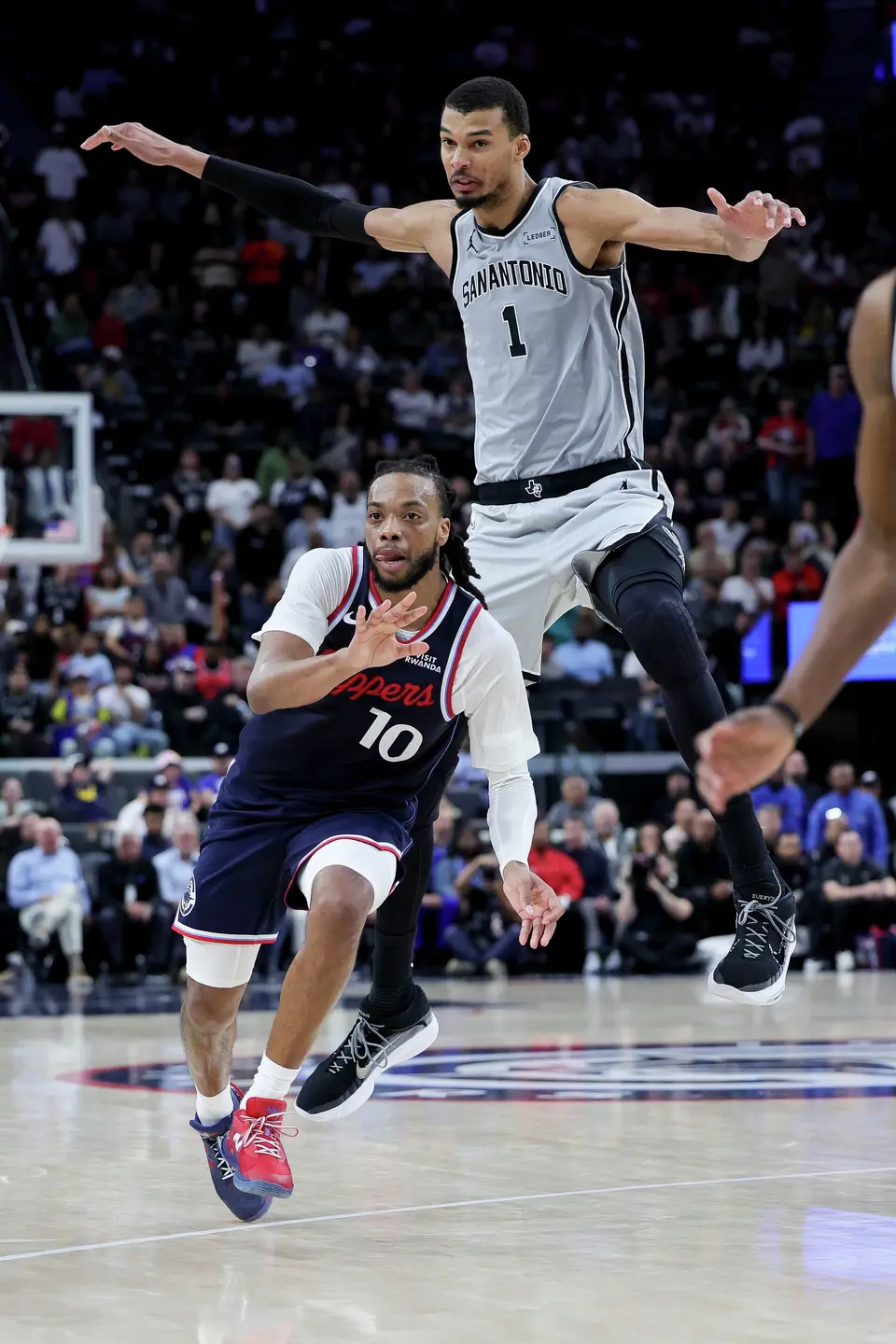 Los Angeles Clippers guard Darius Garland, left, runs past San Antonio Spurs forward Victor Wembanyama during the second half of an NBA basketball game Monday, March 16, 2026, in Inglewood, Calif. (AP Photo/Ryan Sun)