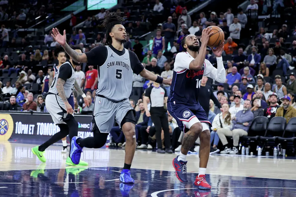 Los Angeles Clippers guard Darius Garland, right, shoots against San Antonio Spurs guard Stephon Castle during the second half of an NBA basketball game Monday, March 16, 2026, in Inglewood, Calif. (AP Photo/Ryan Sun)