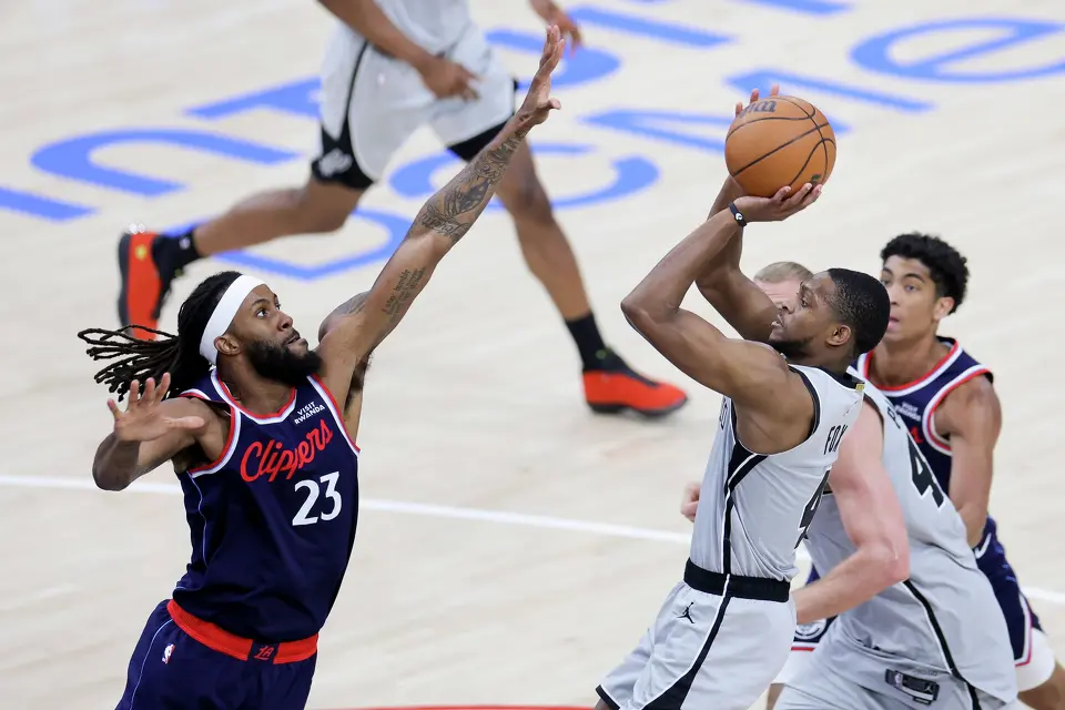 San Antonio Spurs guard De'aaron Fox, right, shoots against Los Angeles Clippers forward Isaiah Jackson during the second half of an NBA basketball game Monday, March 16, 2026, in Inglewood, Calif. (AP Photo/Ryan Sun)