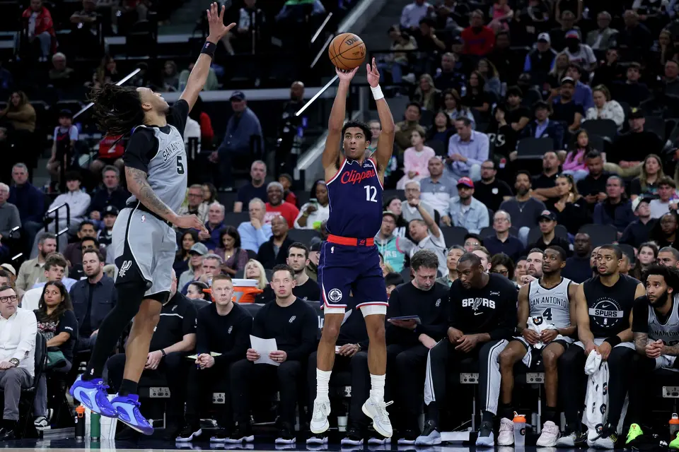 Los Angeles Clippers guard Cam Christie, right, shoots against San Antonio Spurs guard Stephon Castle during the second half of an NBA basketball game Monday, March 16, 2026, in Inglewood, Calif. (AP Photo/Ryan Sun)