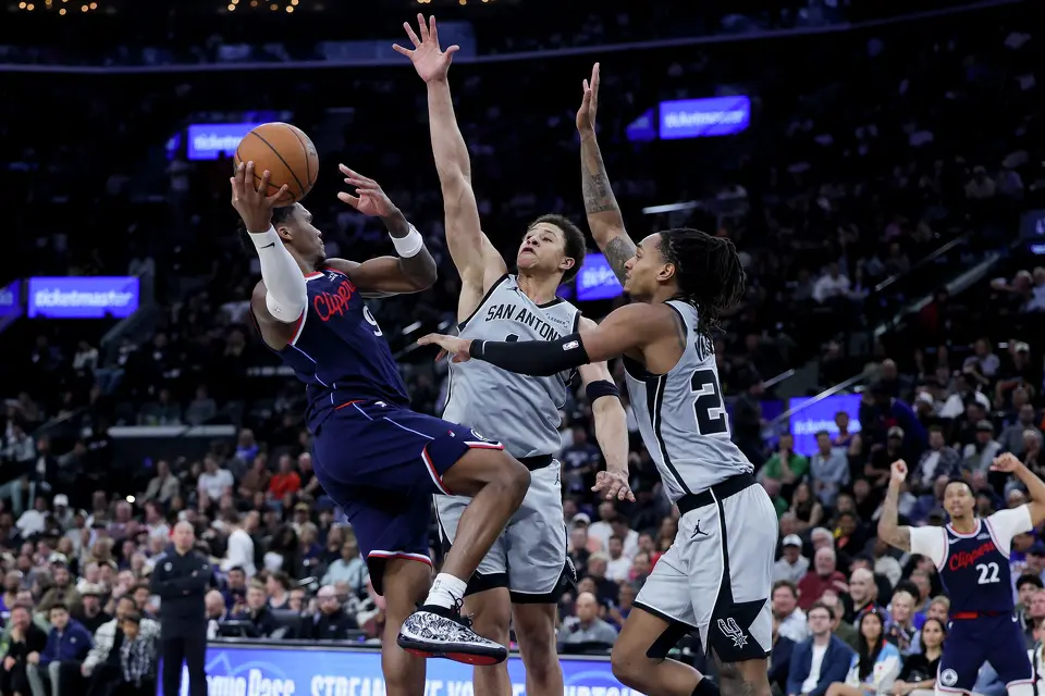 Los Angeles Clippers guard Bennedict Mathurin, left, shoots against San Antonio Spurs guard Carter Bryant, center, and guard Devin Vassell during the second half of an NBA basketball game Monday, March 16, 2026, in Inglewood, Calif. (AP Photo/Ryan Sun)