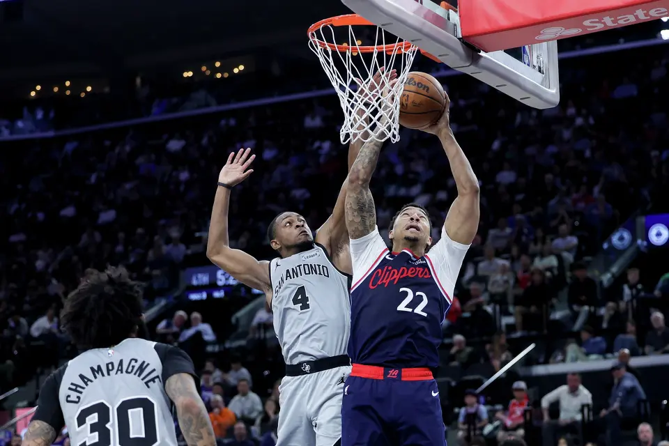 Los Angeles Clippers guard Jordan Miller, right, shoots against San Antonio Spurs guard De'aaron Fox, center, during the second half of an NBA basketball game Monday, March 16, 2026, in Inglewood, Calif. (AP Photo/Ryan Sun)
