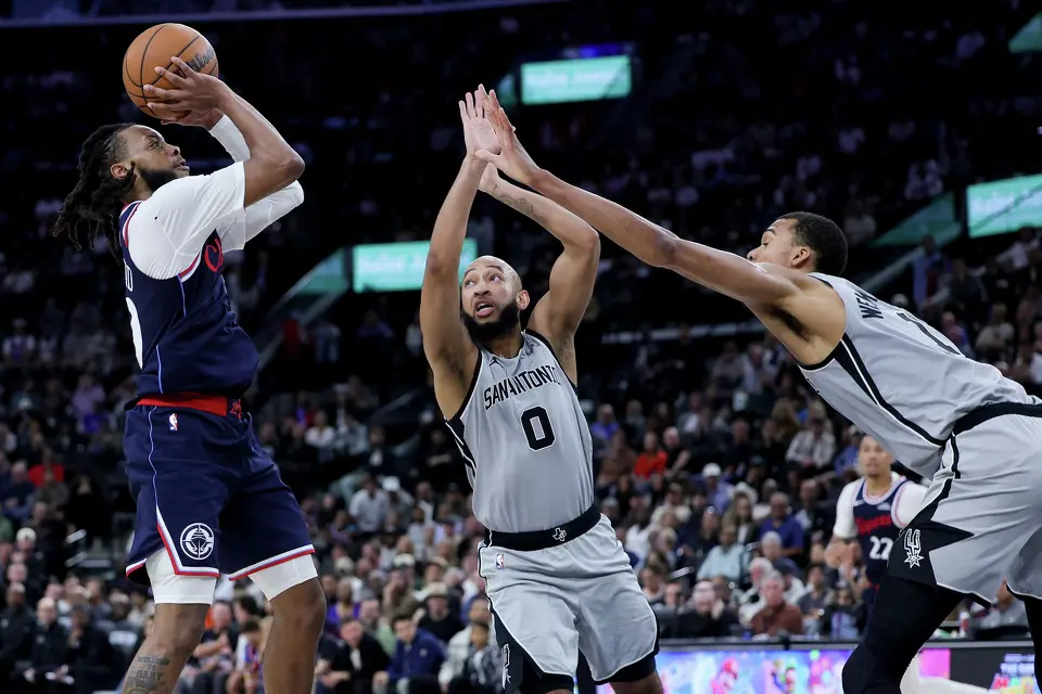 Los Angeles Clippers guard Darius Garland, left, shoots against San Antonio Spurs guard Jordan McLaughlin, center, and forward Victor Wembanyama during the second half of an NBA basketball game Monday, March 16, 2026, in Inglewood, Calif. (AP Photo/Ryan Sun)