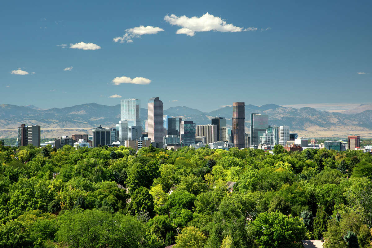 The towering high rises of Denver's downtown sit between the Front Range of the Rocky Mountains to the west and the tree lined neighborhoods and parks of the city to the east.