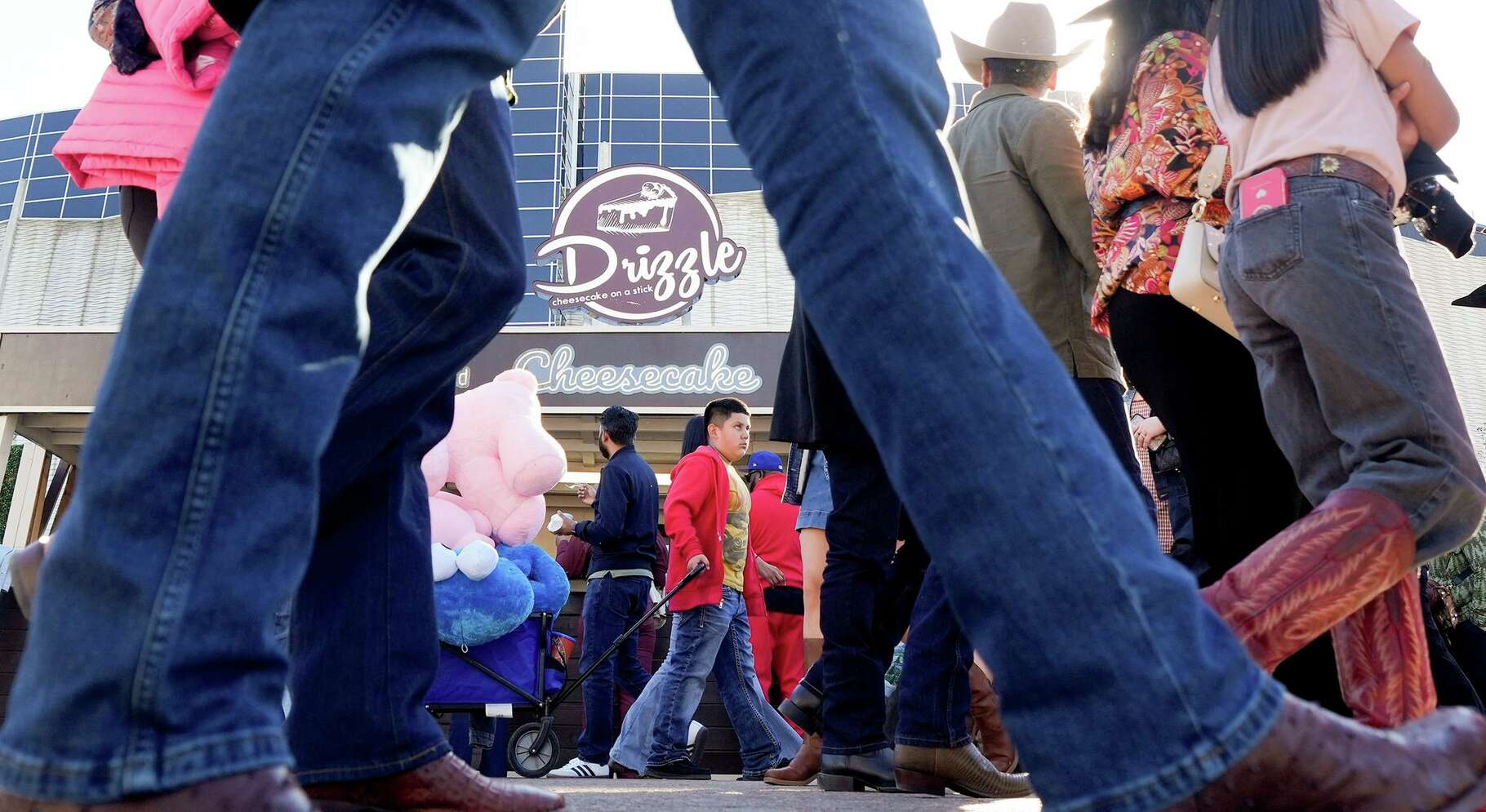 Houston Livestock Show and Rodeo attendees walk by Drizzle Cheesecakes on Tuesday, March 17, 2026.
