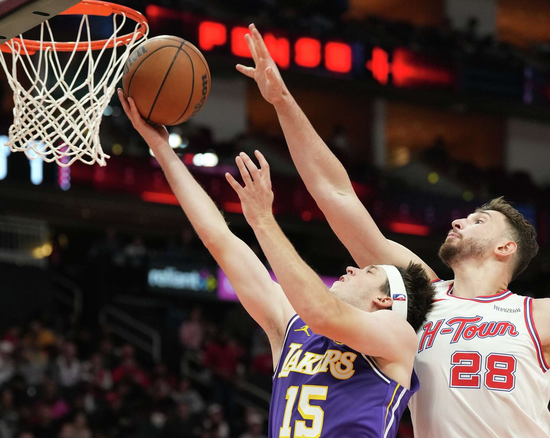 Los Angeles Lakers guard Austin Reaves (15) drives to the basket around Houston Rockets center Alperen Sengun (28) at the Toyota Center in Houston on Wednesday, March 18, 2026.