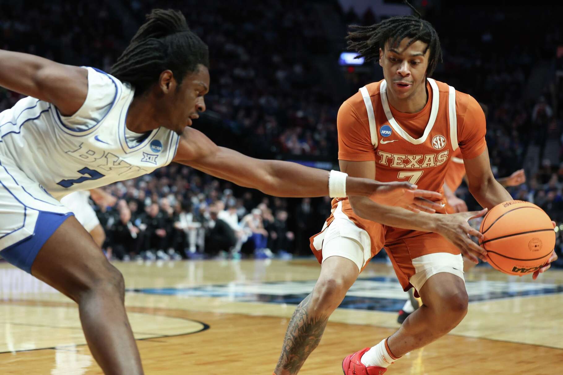 Texas guard Simeon Wilcher (7) tries to hold on to the ball past BYU forward Khadim Mboup (7) during the first half in the first round of the NCAA college basketball tournament Thursday, March 19, 2026, in Portland, Ore. (AP Photo/Craig Mitchelldyer)