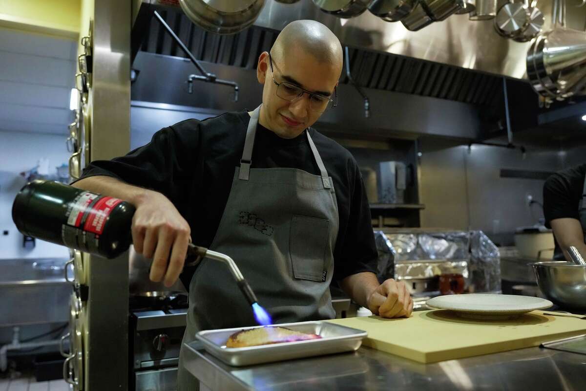 Paolo Justo prepares Spanish French toast in the kitchen at Toga, a yakitori-focused izakaya by Comma Hospitality, ahead of its opening in Houston on Thursday, March 19, 2026.