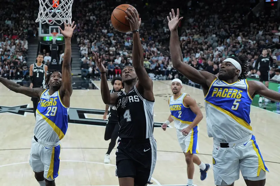 San Antonio Spurs guard De'aaron Fox (4) drives to the basket between Indiana Pacers guard Quenton Jackson (29) and forward Jarace Walker (5) during the first half of an NBA basketball game in San Antonio, Saturday, March 21,2026. (AP Photo/Eric Gay)