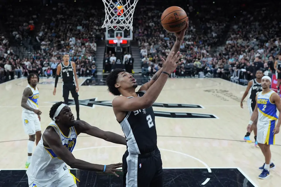 San Antonio Spurs guard Dylan Harper (2) scores past Indiana Pacers forward Jarace Walker (5) during the first half of an NBA basketball game in San Antonio, Saturday, March 21,2026. (AP Photo/Eric Gay)