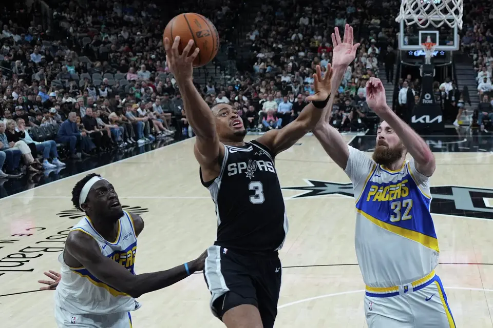 San Antonio Spurs forward Keldon Johnson (3) drives to the basket against Indiana Pacers center Jay Huff (32) during the first half of an NBA basketball game in San Antonio, Saturday, March 21,2026. (AP Photo/Eric Gay)