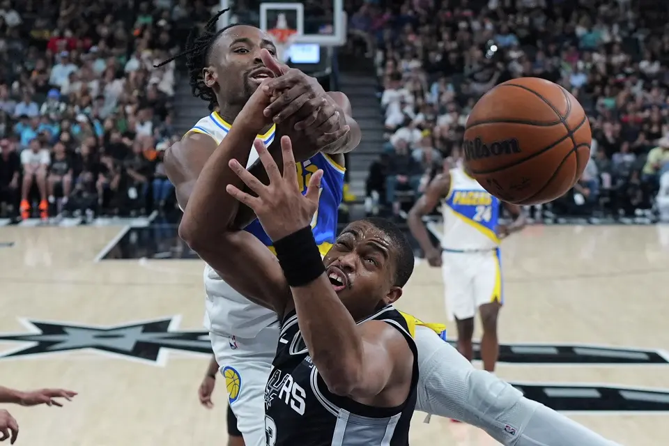 Indiana Pacers guard Aaron Nesmith, left, and San Antonio Spurs forward Keldon Johnson, right, battle for a rebound during the second half of an NBA basketball game in San Antonio, Saturday, March 21,2026. (AP Photo/Eric Gay)