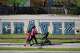 Pedestrians walk past the parking lot of the Cesar Chavez Learning Center in Dallas, Thursday, March 19, 2026. (AP Photo/Julio Cortez)