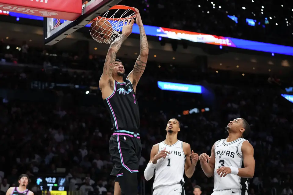 Miami Heat center Kel'el Ware (7) dunks over San Antonio Spurs forward Victor Wembanyama (1) and forward Keldon Johnson (3) during the second half of an NBA basketball game, Monday, March 23, 2026, in Miami. (AP Photo/Lynne Sladky)