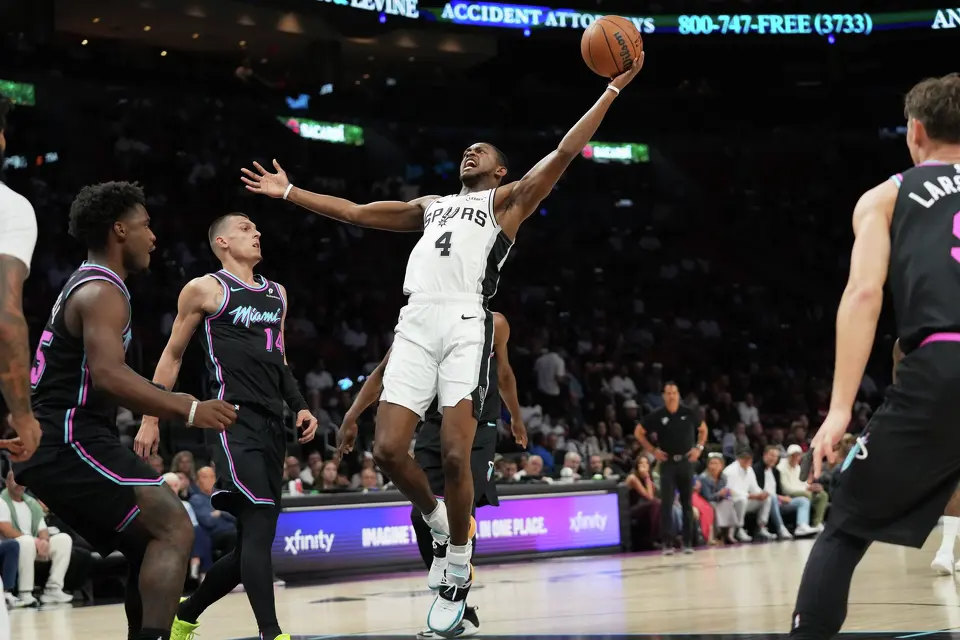 San Antonio Spurs guard De'aaron Fox (4) goes to the basket against Miami Heat guard Tyler Herro (14) during the first half of an NBA basketball game, Monday, March 23, 2026, in Miami. (AP Photo/Lynne Sladky)