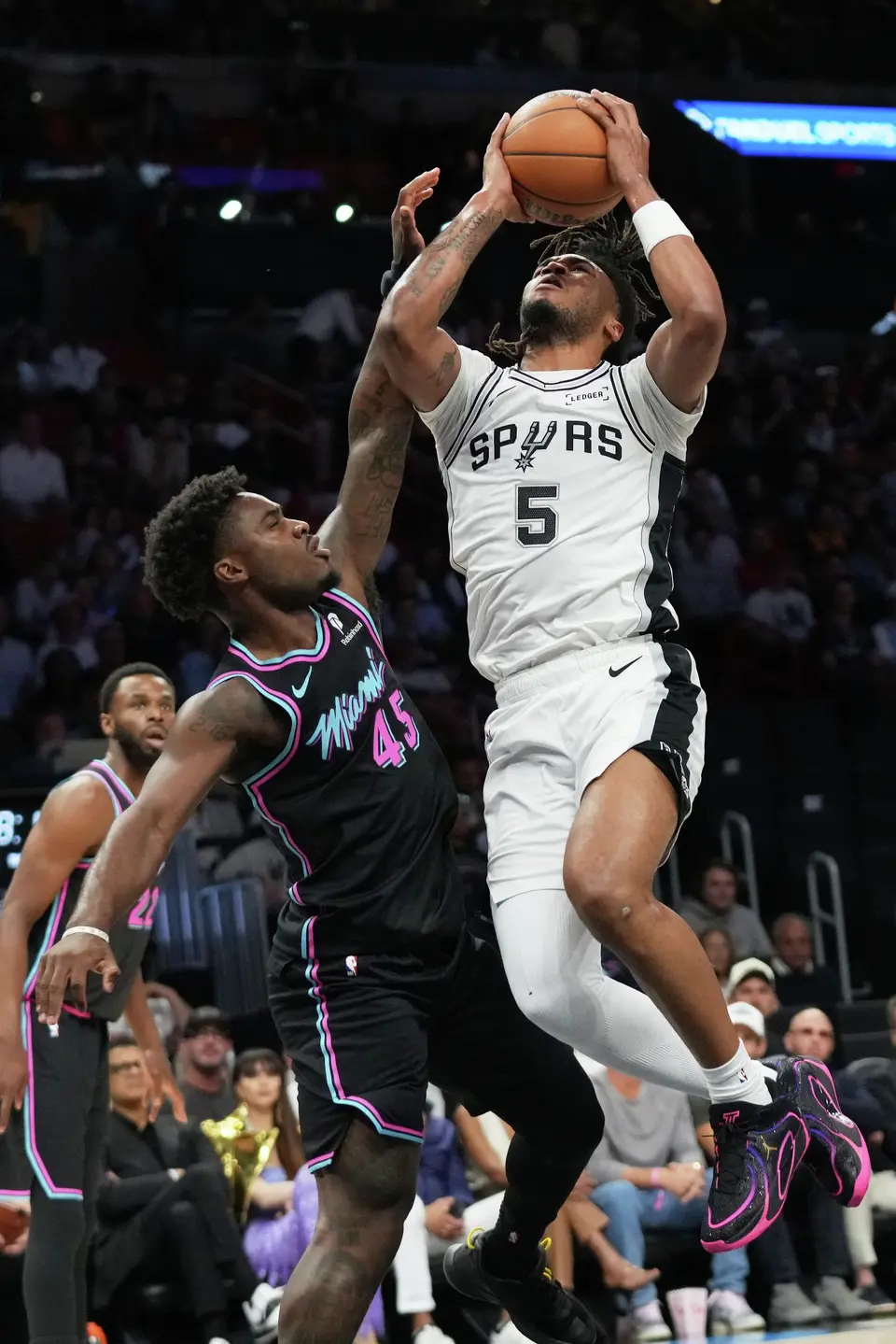 San Antonio Spurs guard Stephon Castle (5) goes to the basket as Miami Heat guard Davion Mitchell (45) defends during the first half of an NBA basketball game, Monday, March 23, 2026, in Miami. (AP Photo/Lynne Sladky)
