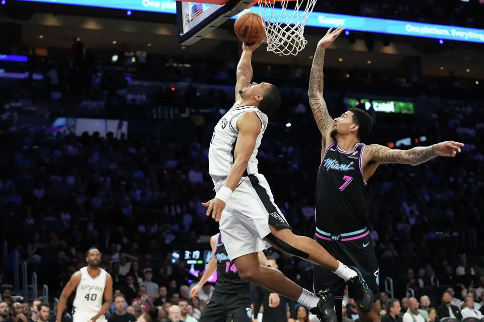 San Antonio Spurs forward Keldon Johnson, left, shoots over Miami Heat center Kel'el Ware (7) during the first half of an NBA basketball game, Monday, March 23, 2026, in Miami. (AP Photo/Lynne Sladky)
