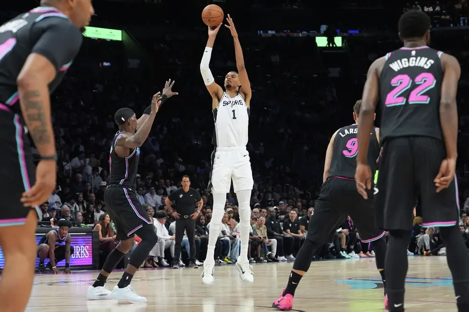San Antonio Spurs forward Victor Wembanyama (1) shoots a three-point basket over Miami Heat center Bam Adebayo (13) during the first half of an NBA basketball game, Monday, March 23, 2026, in Miami. (AP Photo/Lynne Sladky)