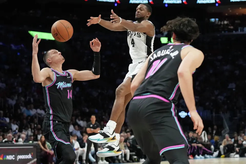 San Antonio Spurs guard De'aaron Fox (4) loses control of the ball to Miami Heat guard Tyler Herro (14) during the first half of an NBA basketball game, Monday, March 23, 2026, in Miami. (AP Photo/Lynne Sladky)