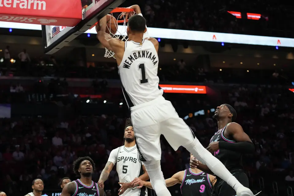 San Antonio Spurs forward Victor Wembanyama (1) dunks over Miami Heat center Bam Adebayo, right, during the first half of an NBA basketball game, Monday, March 23, 2026, in Miami. (AP Photo/Lynne Sladky)