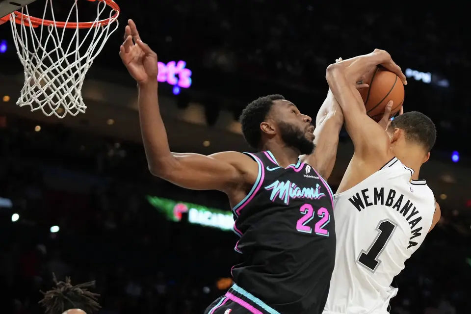 Miami Heat forward Andrew Wiggins (22) goes for a rebound against San Antonio Spurs forward Victor Wembanyama (1) during the second half of an NBA basketball game, Monday, March 23, 2026, in Miami. (AP Photo/Lynne Sladky)