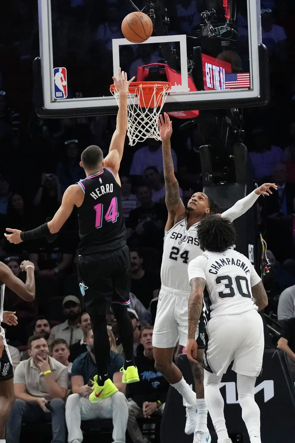 Miami Heat's Tyler Herro (14) shoots over San Antonio Spurs guard Devin Vassell (24) during the first half of an NBA basketball game, Monday, March 23, 2026, in Miami. (AP Photo/Lynne Sladky)