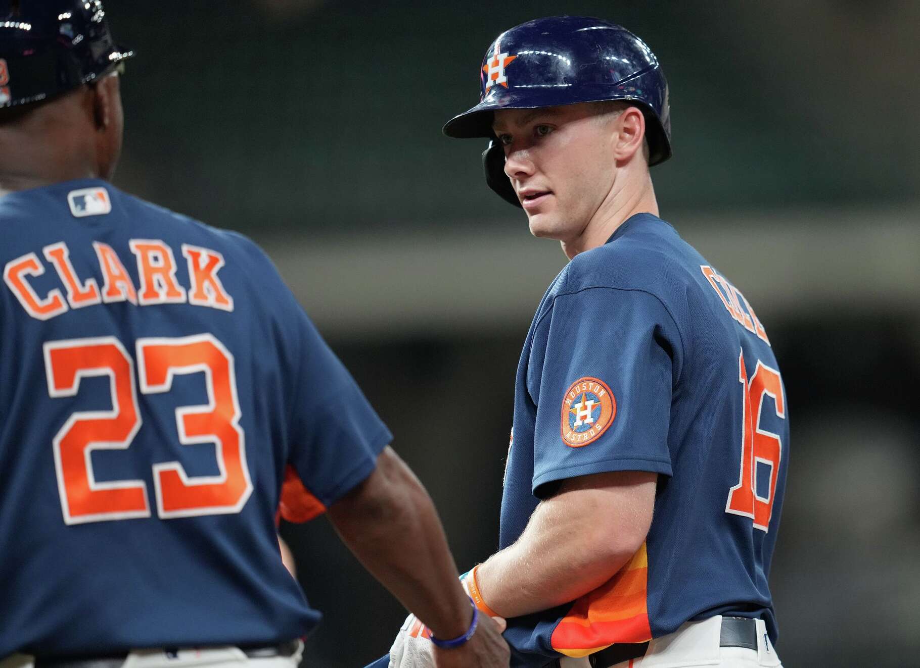 Zach Cole (16) chats with first base coach Dave Clark (23) after getting on first at Daikin Park in Houston on Monday, March 23, 2026.