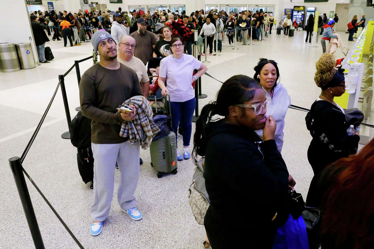 Air travelers wait in line as they progress to the TSA security checkpoint in Terminal A at the George Bush Intercontinental Airport, Monday, March 23, 2026, in Houston. (AP Photo/Michael Wyke)