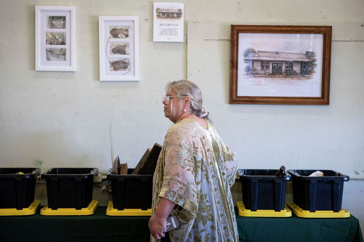 Dondi Persyn walks by boxes of items from the floods during an event for the group